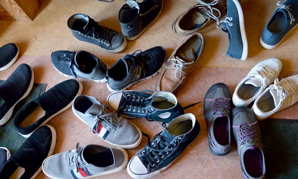 Picture of a pile of shoes left by Koru students at a retreat